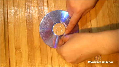 Взяла DVD диск и остатки разных страз и сделала оригинальный подсвечник.